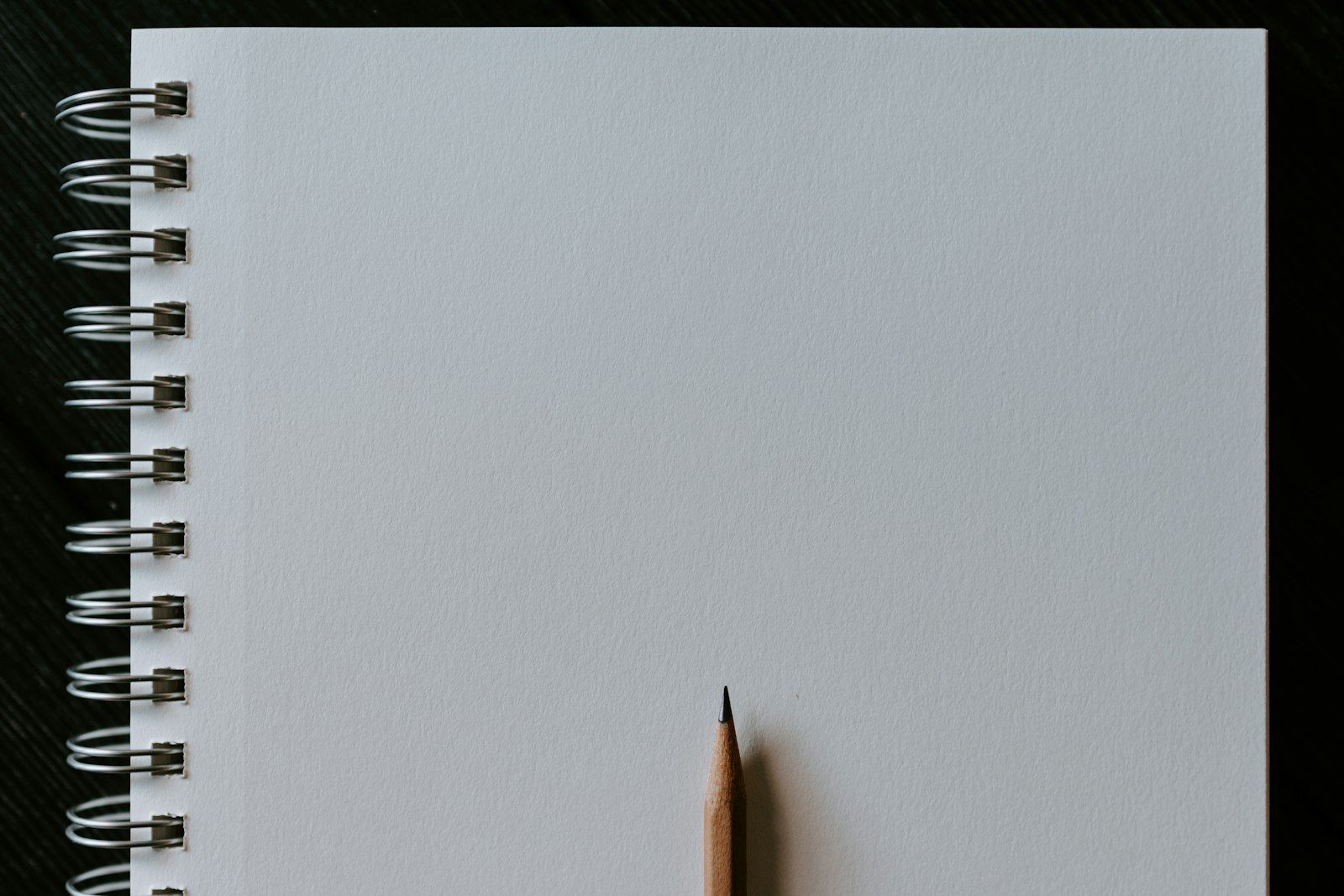 A blank spiral sketchbook with a pencil